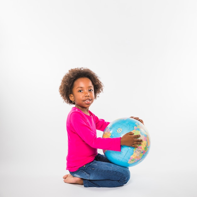 Free photo cute child with globe in studio