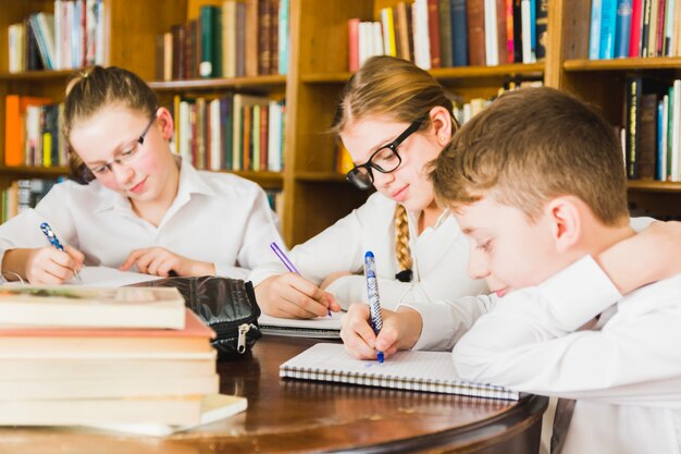 かわいい子供たちが学校の図書館で勉強