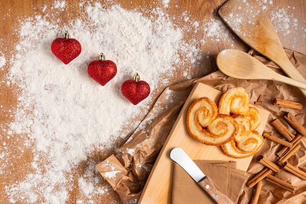 Foto gratuita simpatica composizione per san valentino con pasticcini e bastoncini di cannella