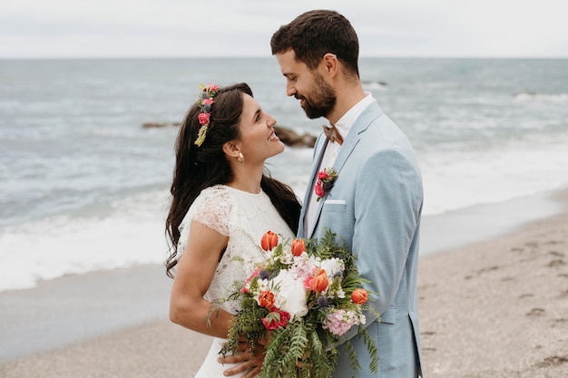 ビーチでの結婚式を祝うかわいいカップル