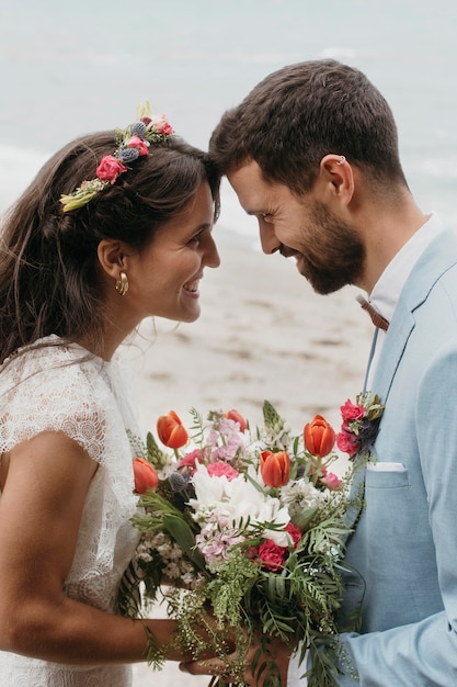 無料写真 ビーチでの結婚式を祝うかわいいカップル