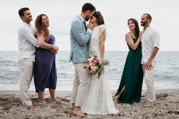 무료 사진 해변에서 그들의 결혼식을 축 하하는 귀여운 커플