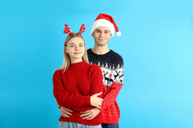 Cute couple in christmas clothes on blue background