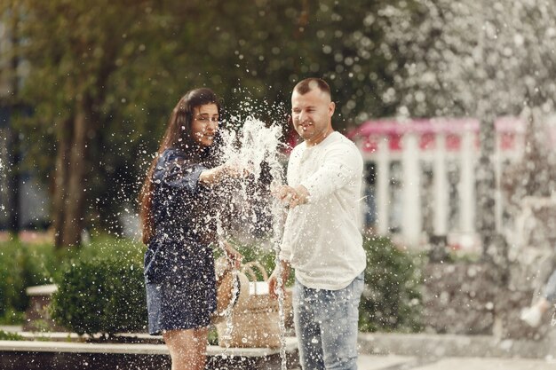 Cute couple in a city. Man in a white shirt. People walks.