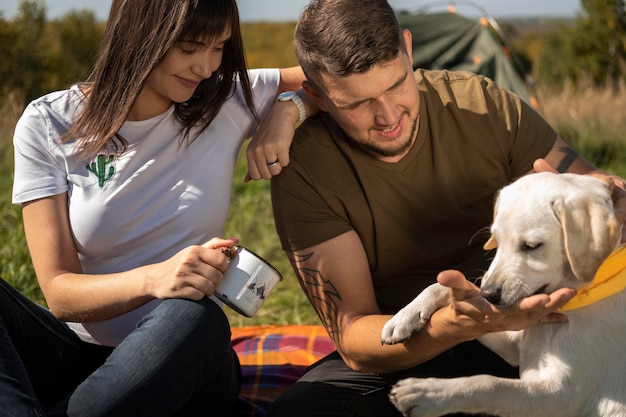 Foto gratuita coppia carina e cane all'aperto