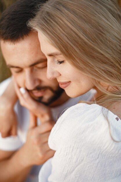 Cute couple in a field. Lady in a white blouse. Guy in a white shirt