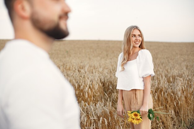 Cute couple in a field. Lady in a white blouse. Guy in a white shirt