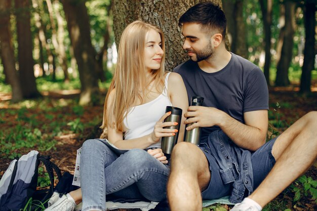 Cute couple have a rest in a summer forest