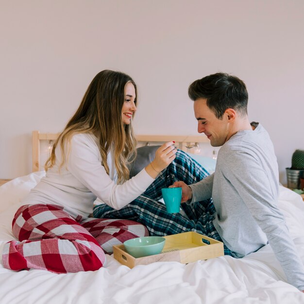 Cute couple having breakfast in bed