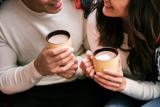 Cute couple holding hot drinks