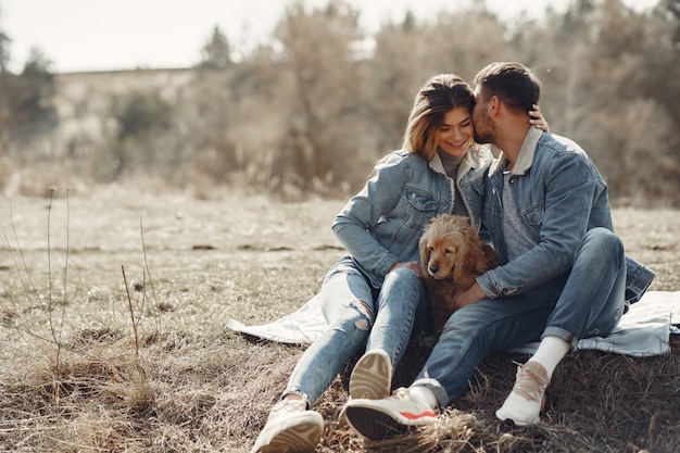 Free photo cute couple in a jeans clothes in a spring field