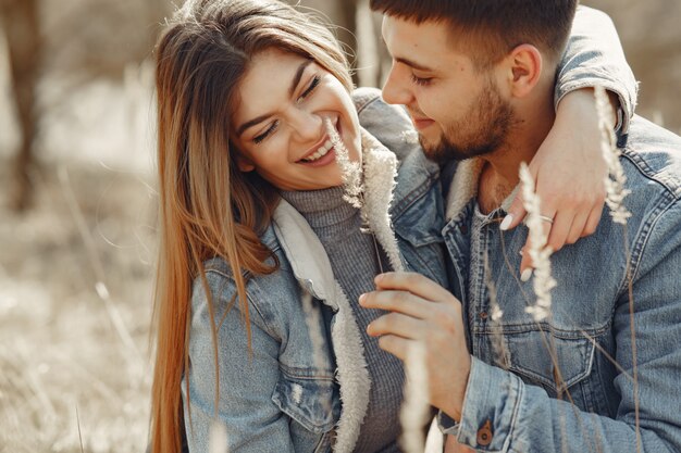 Cute couple in a jeans clothes in a spring field