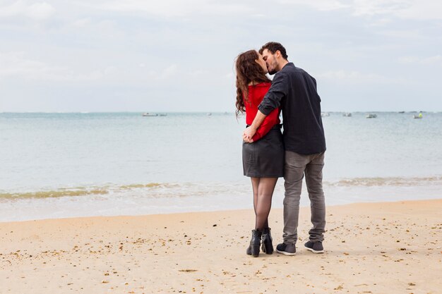 Cute couple kissing on sea shore 