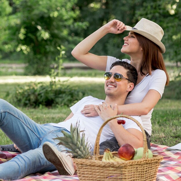 Cute couple looking away lying on a blanket