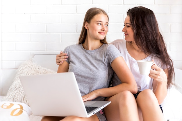 Free photo cute couple looking at each other holding a laptop