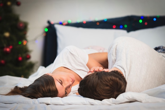 Free photo cute couple looking at eacother in bed