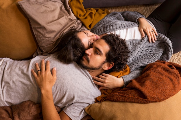 Free photo cute couple lying together on the sofa