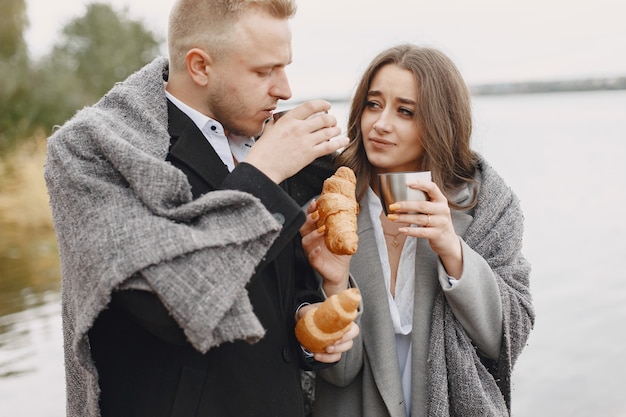 Милая пара в парке. Дама в сером пальто. Люди с термосом и круассаном.