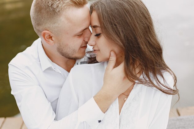 Cute couple in a park. Lady in a white shirt. People on the pier.