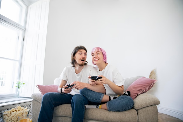 Бесплатное фото Милая пара играет в видеоигры на диване