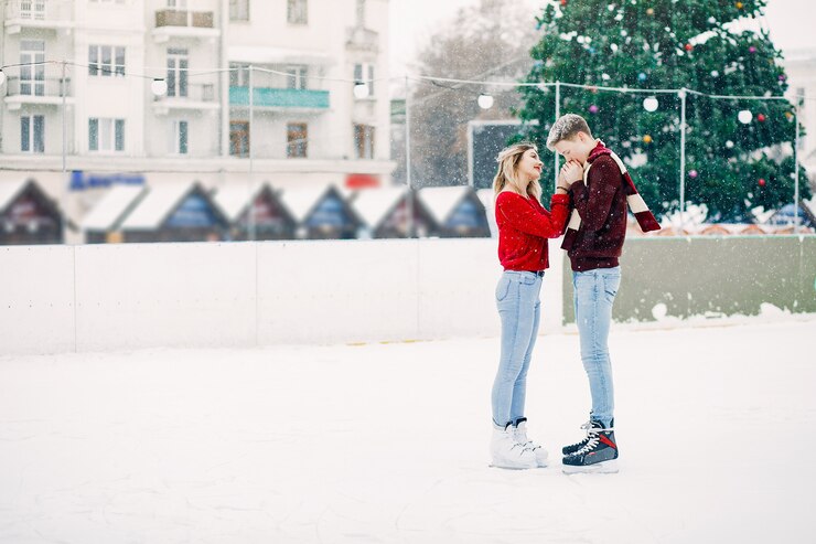 Free Photo cute couple in a red sweaters having fun in a ice arena