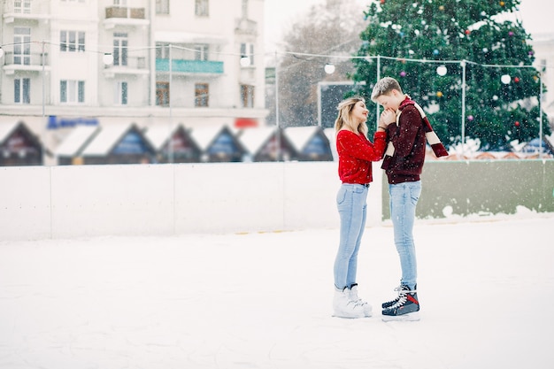 얼음 경기장에서 재미 빨간 스웨터에 귀여운 커플