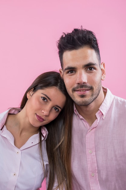 Cute couple standing on pink background