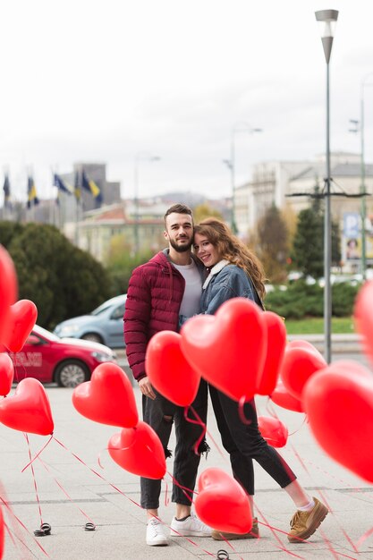 Cute couple surrounded by heart balloons