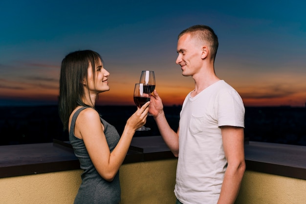 Cute couple toasting wine on rooftop