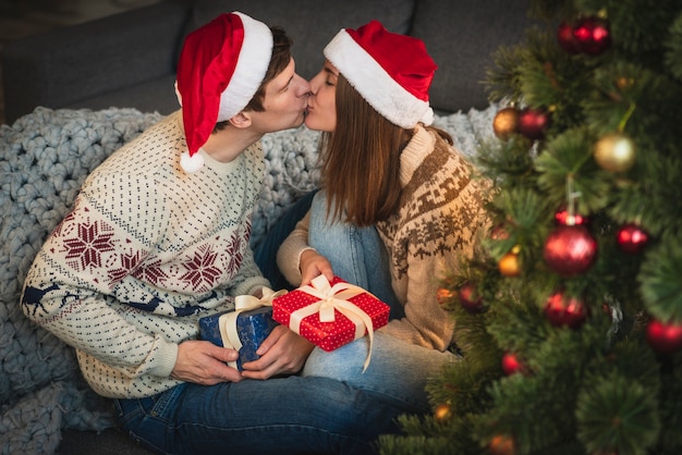 Милая пара с рождественских подарков целоваться