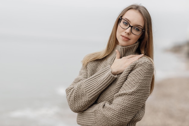 海の近くの屋外のかわいい居心地の良い笑顔の女性