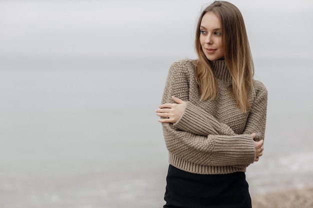 Foto gratuita donna sorridente accogliente carina all'aperto vicino al mare