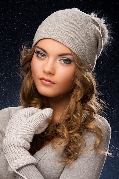 Free photo cute curly girl wearing mittens during snowfall