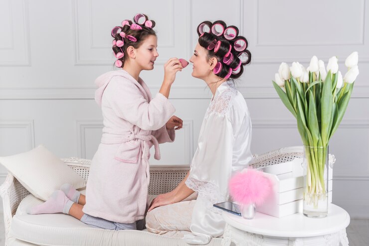 Free Photo cute daughter putting powder on mothers face