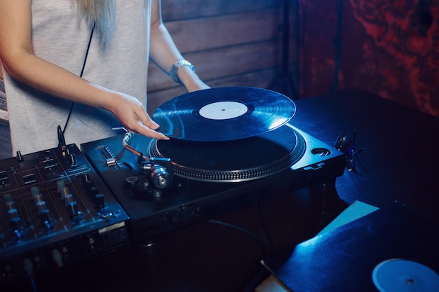 Cute dj woman having fun playing music at club party