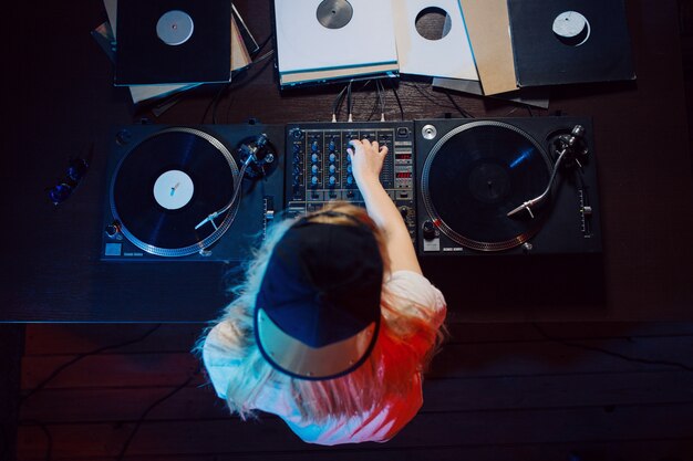 Cute dj woman having fun playing music at club party