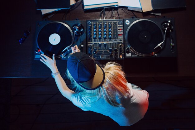 Cute dj woman having fun playing music at club party