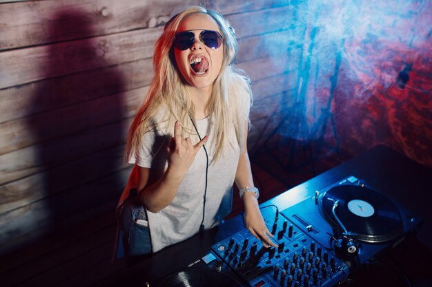 Cute dj woman having fun playing music at club party