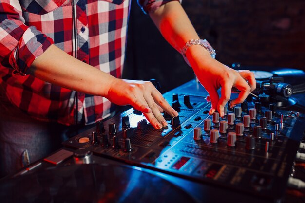 Cute dj woman having fun playing music at club party