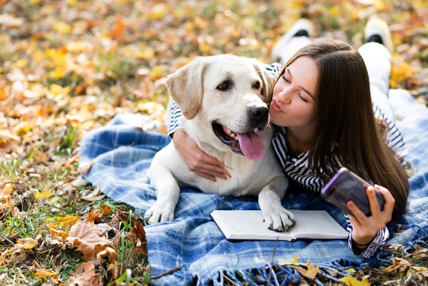 Милая собака с молодой женщиной в парке