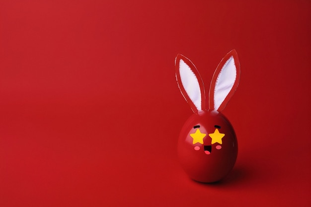 Foto gratuita simpatico uovo di pasqua con sfondo rosso