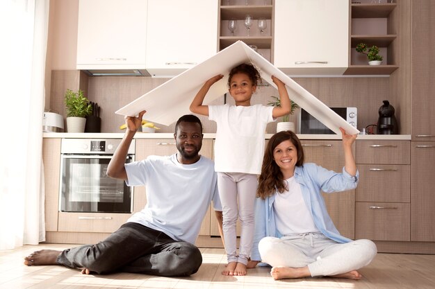 Cute family holding a roof above their head