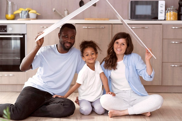 Free photo cute family holding a roof above their head