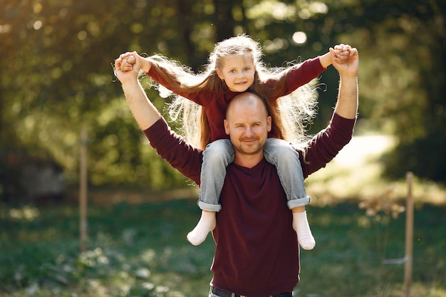 Famiglia sveglia che gioca in un parco di autunno