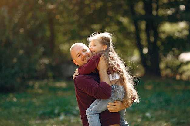 Famiglia sveglia che gioca in un parco di autunno