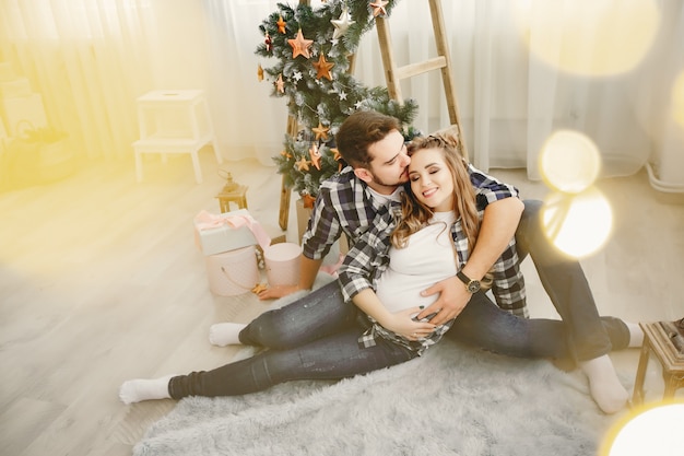 Cute family sitting near Christmas tree