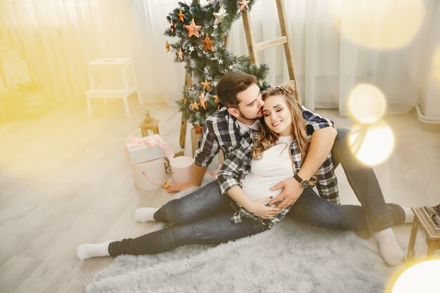 Cute family sitting near Christmas tree