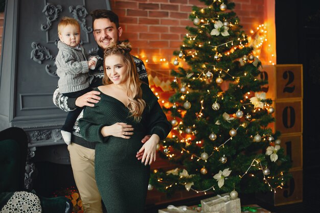 Cute family sitting near Christmas tree