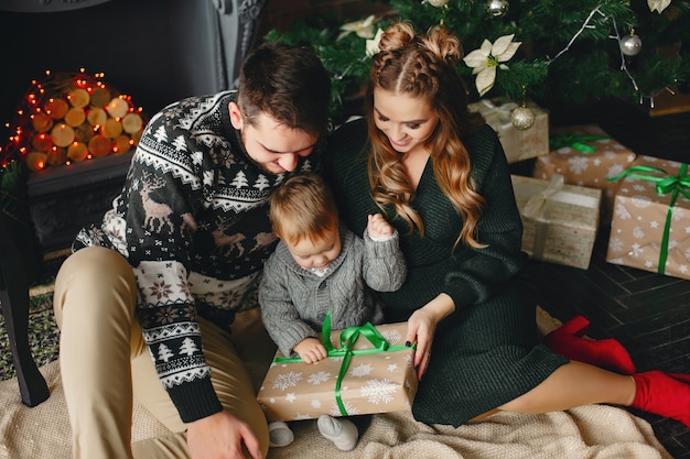 Cute family sitting near Christmas tree