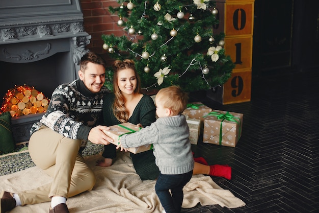 Cute family sitting near Christmas tree